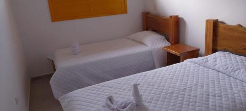 a bedroom with two beds and a mirror at Hostería santa María in Filandia
