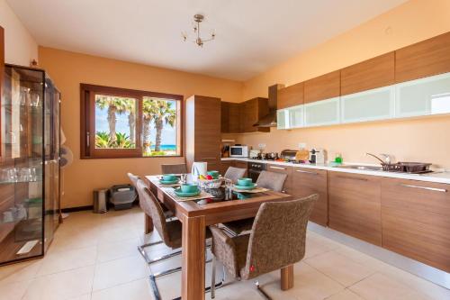 a kitchen with a wooden table and chairs at Harbour Views Gozitan Villa Shared Pool - Happy Rentals in Mġarr