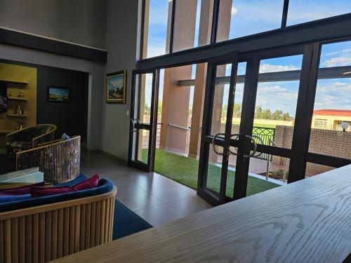 a room with sliding glass doors with a view of a yard at TACOA Boutique Hotel in Westonaria