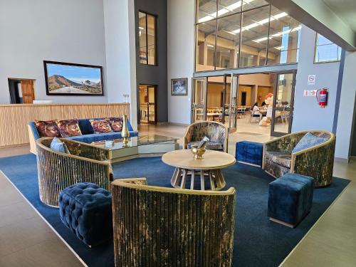 a lobby with a couch and chairs and a table at TACOA Boutique Hotel in Westonaria