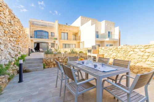 a patio with a table and chairs in front of a building at Ta'Siku Gozitan villa Pool & hot tub - Happy Rentals in Il-Pergla