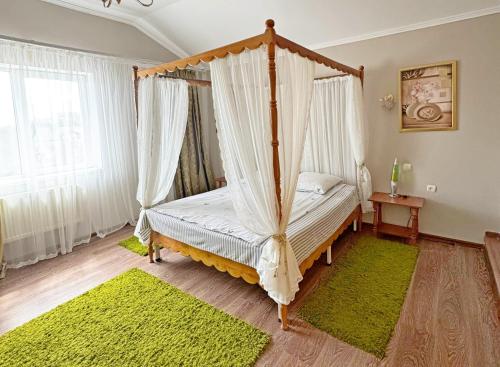 a bedroom with a canopy bed with green rugs at Готель-Ресторан Соната in Sambir