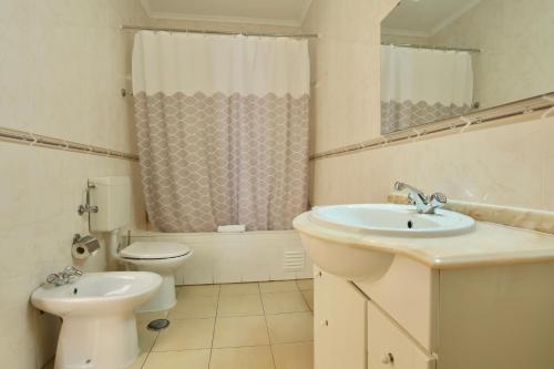 a white bathroom with a sink and a toilet at Rialgarve in Faro
