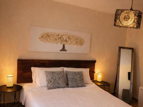 a bedroom with a white bed with two pillows at Chalet in Rivero de Posadas with Pool in Rivero de Posadas