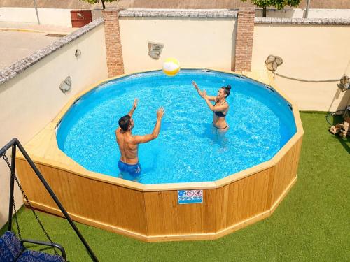 two people playing with a ball in a swimming pool at Chalet in Rivero de Posadas with Pool in Rivero de Posadas