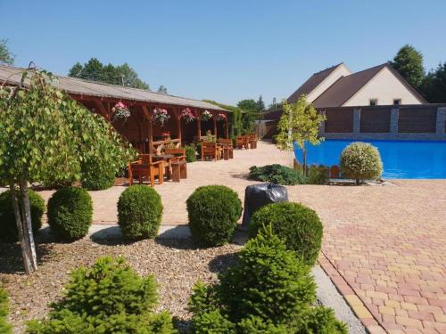 a garden with a table and chairs and a pool at Apartamenty Maciejowy Sad in Sady Dolne