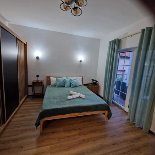 a bedroom with a bed with a green blanket at Villa Breza in Bihać