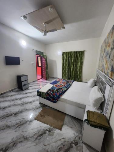 a bedroom with a large bed and a red door at RÉSIDENCE MAME DIARRA kl in Kaolack