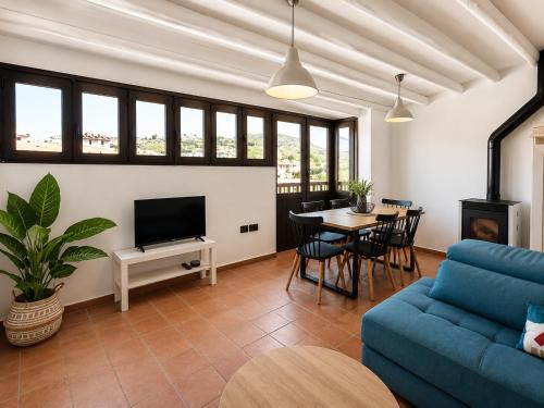 a living room with a blue couch and a table at Sésamo Apartamento in Hervás