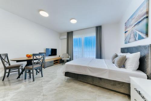 a bedroom with a large bed and a dining table at ARA Lux Apartments in Utjeha