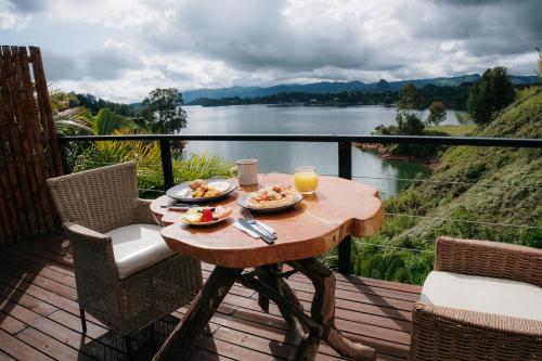 a table with food on a balcony with a view of a river at Bliss Sanctuary Vista - Glamping and Club in Guatapé
