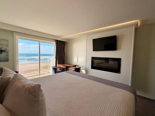 a hotel room with a bed and a view of the ocean at The Sandcastle Beachfront Hotel in Lincoln City
