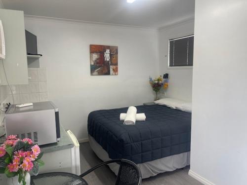 a bedroom with a bed and a desk with a tv at Rivergums Caravan Park in Goondiwindi