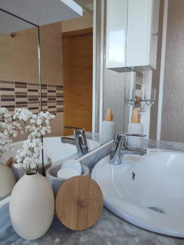 a bathroom with a white sink and a mirror at Apartamento Duplex con jardín A Casiña de Divina in Lago