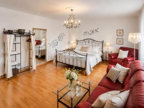 a living room with a bed and a red couch at Erholungs-Apartment mit Balkon nahe Therme & Klinik in Bad Lippspringe