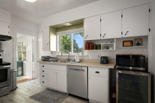 a kitchen with white cabinets and a sink and a window at Yellow York House in Bellingham