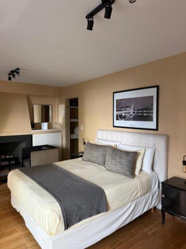 a bedroom with a large white bed and a piano at Maitre Hotel Boutique in Buenos Aires
