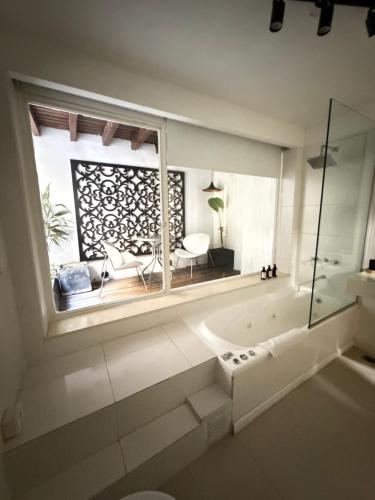 a bathroom with a large window and a bath tub at Maitre Hotel Boutique in Buenos Aires