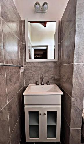 a bathroom with a white sink and a mirror at Departamento Olmos in Mina Clavero
