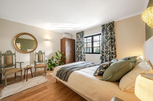 a bedroom with a large bed and a mirror at Сasa do Cedro in Colares