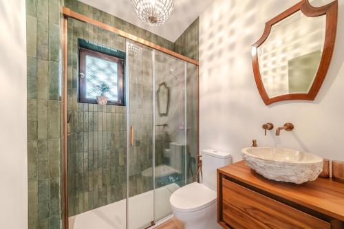 a bathroom with a sink and a glass shower at Сasa do Cedro in Colares