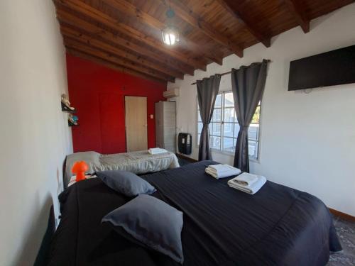 a bedroom with a large black bed in a room at Sol y Luna Hospedaje in Monte Grande