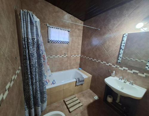 a bathroom with a tub and a toilet and a sink at Sol y Luna Hospedaje in Monte Grande