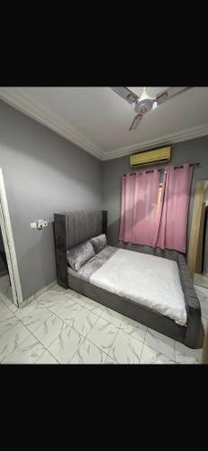 a bedroom with a bed with a pink window at Apartment 2 Brufut Residencies in Brufut