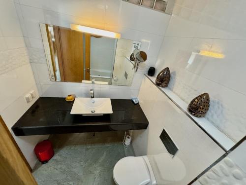 a bathroom with a sink and a toilet and a mirror at Sudresidence in Agadir