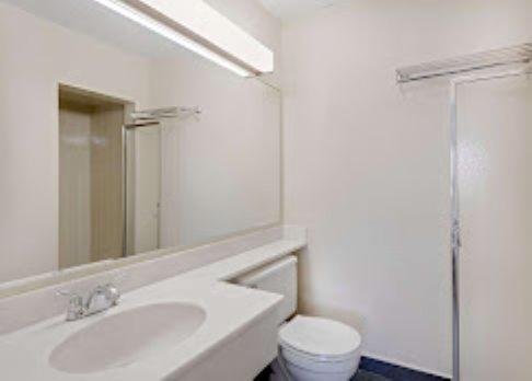 a white bathroom with a sink and a toilet at Lincoln Way Inn in Chambersburg
