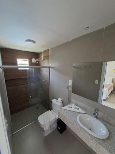 a bathroom with a sink and a toilet and a mirror at Pousada das Araras in Maceió