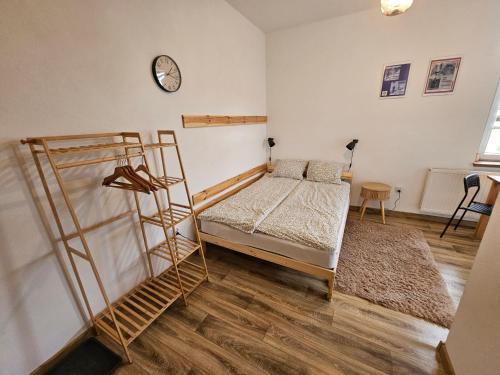 a bedroom with a bunk bed and a clock on the wall at Roland Apartamenty in Świeradów-Zdrój