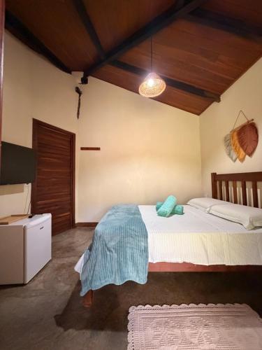a bedroom with a bed with a blue blanket on it at Pousada Cajuzinho do Cerrado in Cavalcante