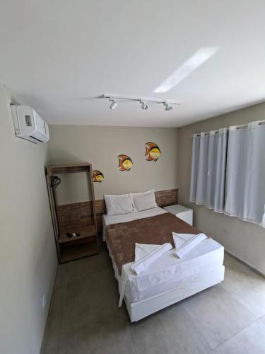 a small bedroom with a bed and a mirror at Pousada das Araras in Maceió