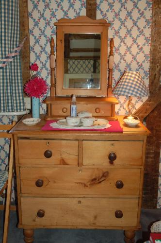 a wooden dresser with a mirror on top of it at Clayton Wickham Farmhouse in Hurstpierpoint