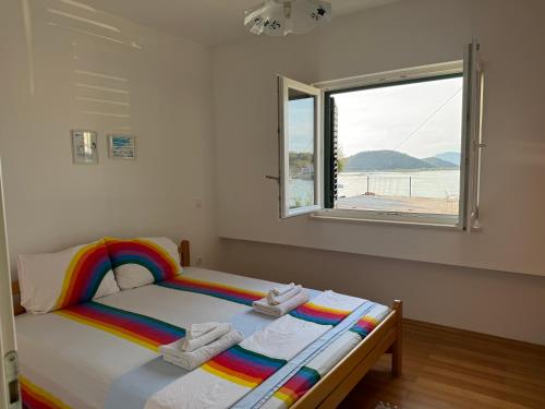 a bedroom with a rainbow bed with a window at 2 bed Comfy Gem: Functional, Ideal Location, Steps to the Beach in Blace