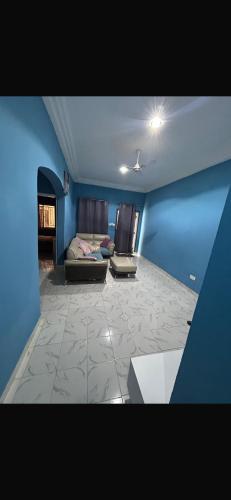 a living room with a couch and a blue wall at Apartment 3 Brufut Residencies in Brufut