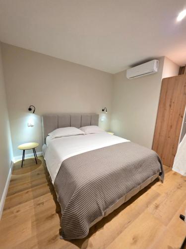 a bedroom with a large bed and a wooden floor at JACUZZI LIVING TIRANA center 1 in Tirana