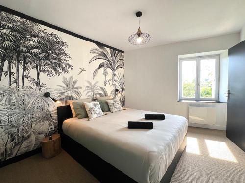 a bedroom with a large bed with a tropical wallpaper at L'Héritage, Loft design et pierre in Dol-de-Bretagne