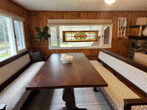 a living room with a wooden table and two benches at Barron Brook Inn in Whitefield