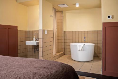 a bathroom with a tub and a sink at Winnedumah Hotel in Independence