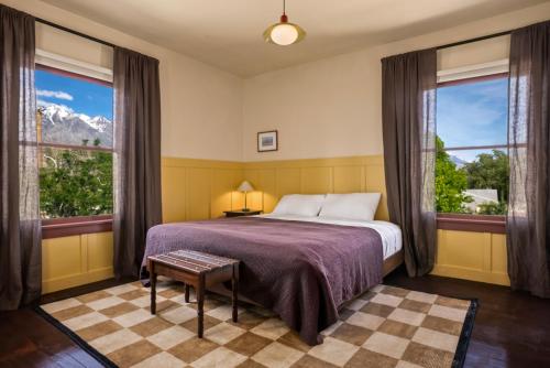 a bedroom with a bed and two large windows at Winnedumah Hotel in Independence