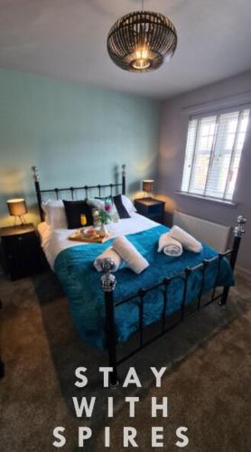a bedroom with a bed with a blue bedspread at The Farrier's recently refurbished 3 bedroom comfy and cosy bolt hole close to Cannock town centre in Hednesford