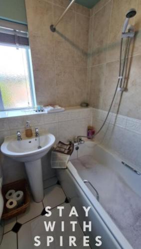a bathroom with a sink and a bath tub and a sink at The Farrier's recently refurbished 3 bedroom comfy and cosy bolt hole close to Cannock town centre in Hednesford