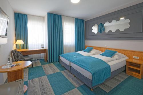 a hotel room with a bed and a desk at Friends Hotel Kerpen in Kerpen