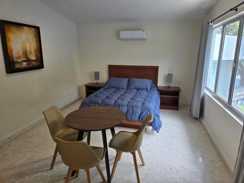 a bedroom with a bed and a table and chairs at Cumbre Guesthouse in Monterrey