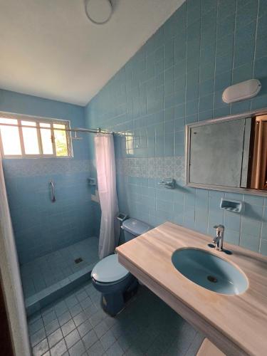 a bathroom with a sink and a toilet and a mirror at Cumbre Guesthouse in Monterrey