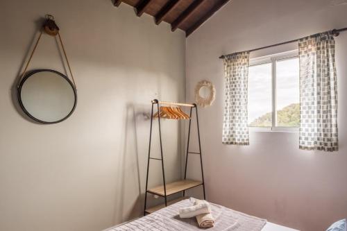 a bedroom with a bed and a mirror and a window at Ben House, private parking in Ponta Delgada