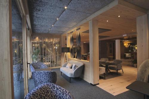 a living room with chairs and a couch and a table at Cevedale Living Romance Hotel in Cogolo