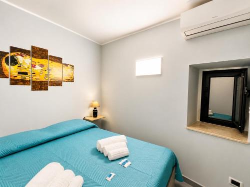 a bedroom with a blue bed and a mirror at Sun Apartments in Agrigento